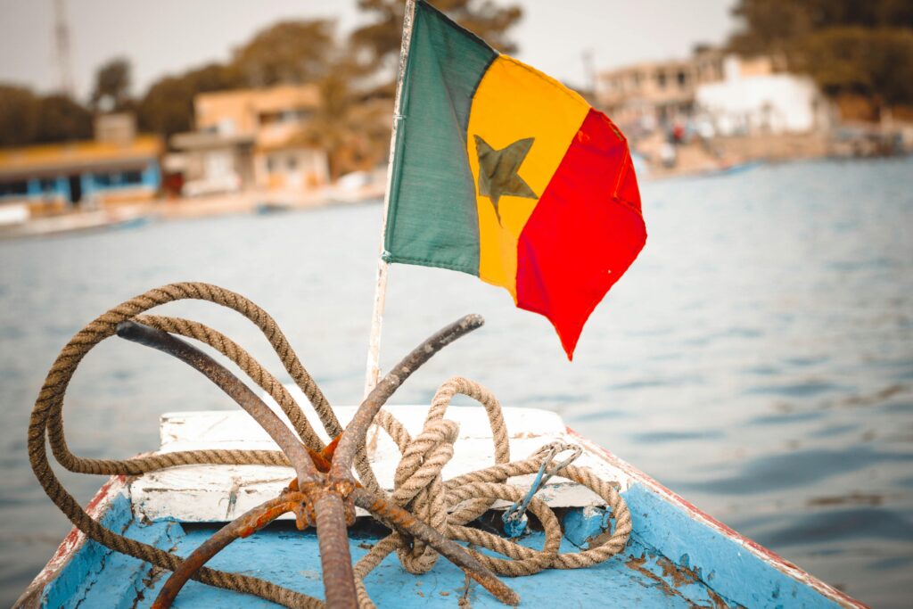 Colorful Senegalese flag and nautical ropes on a boat deck, perfect for travel themes.
